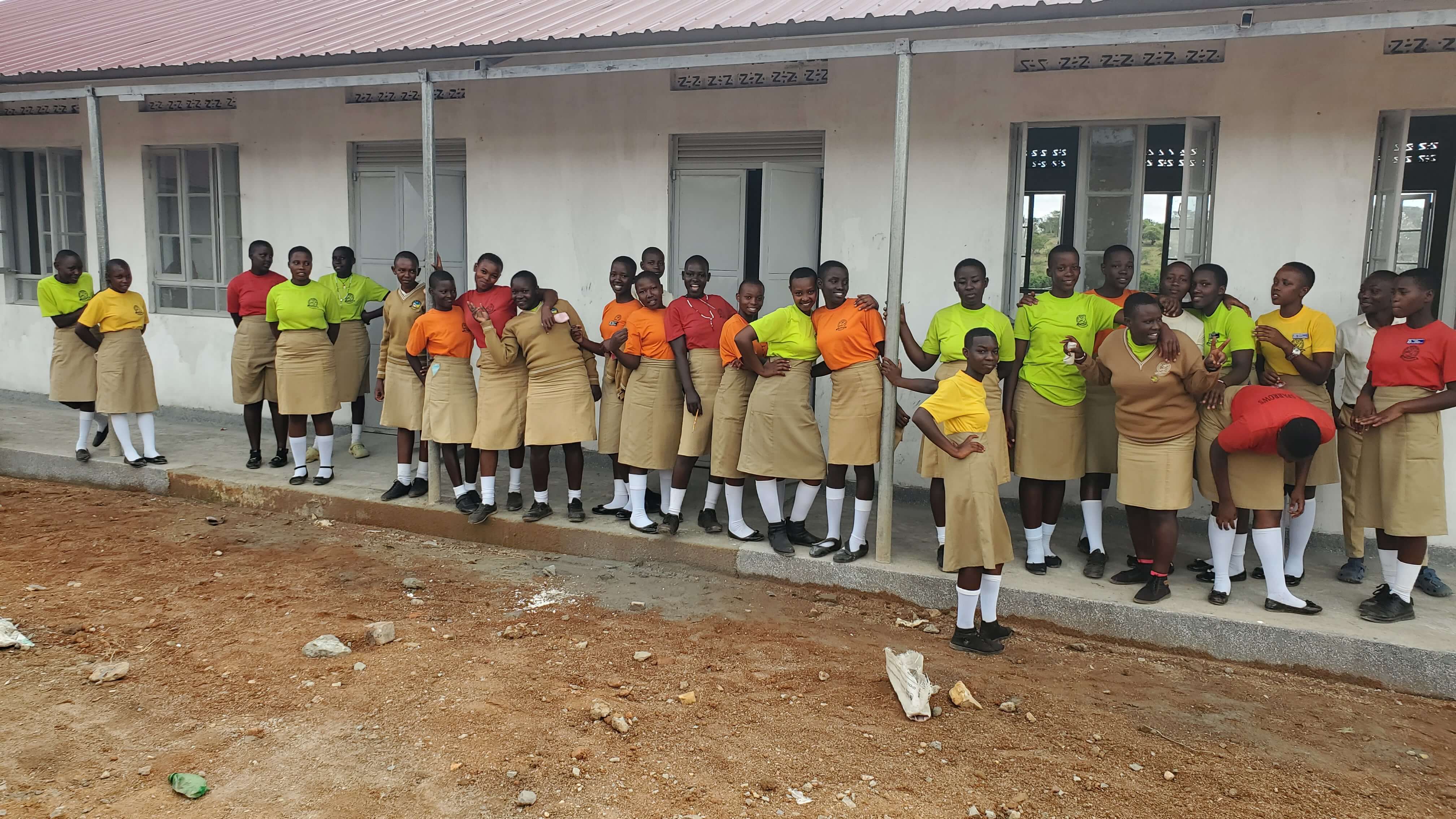 Students standing in front of the new school building at Kasagama Secondary School.